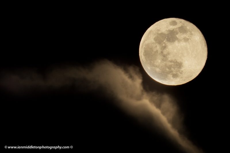 Easter blue moon of March 2018 rising out of the clouds after a rainstorm