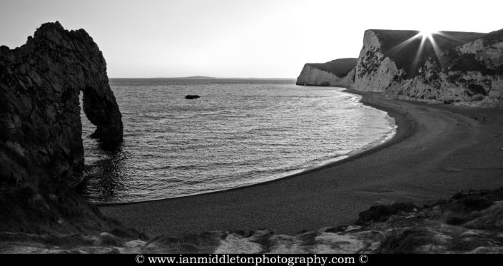 Durdle Door beach as the sun disappears over the cliffs, Dorset, England. Durdle door is one of the many stunning locations to visit on the Jurassic coast in southern England.