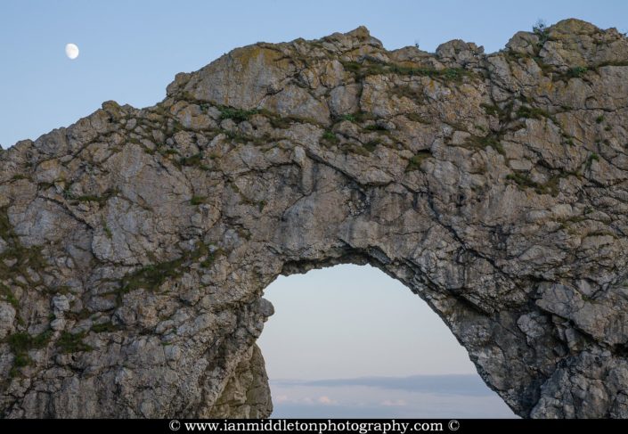 Close up of Durdle Door in the evening with the rising moon above it, Dorset, England. Durdle door is one of the many stunning locations to visit on the Jurassic coast in southern England.