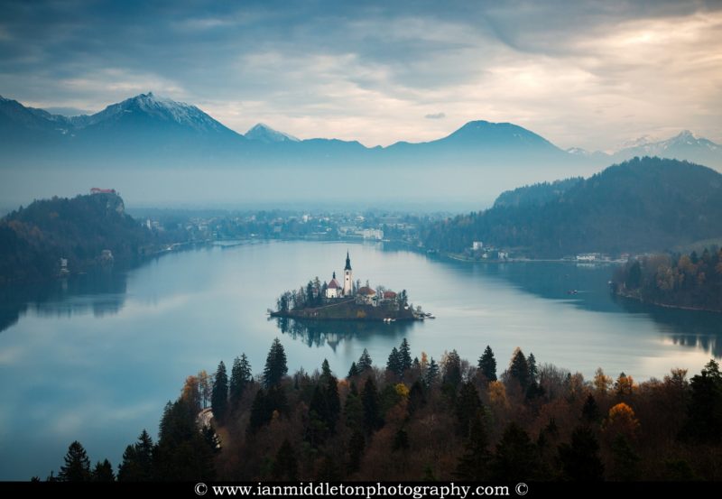 View across Lake Bled to the island church and clifftop castle from Ojstrica, Slovenia.