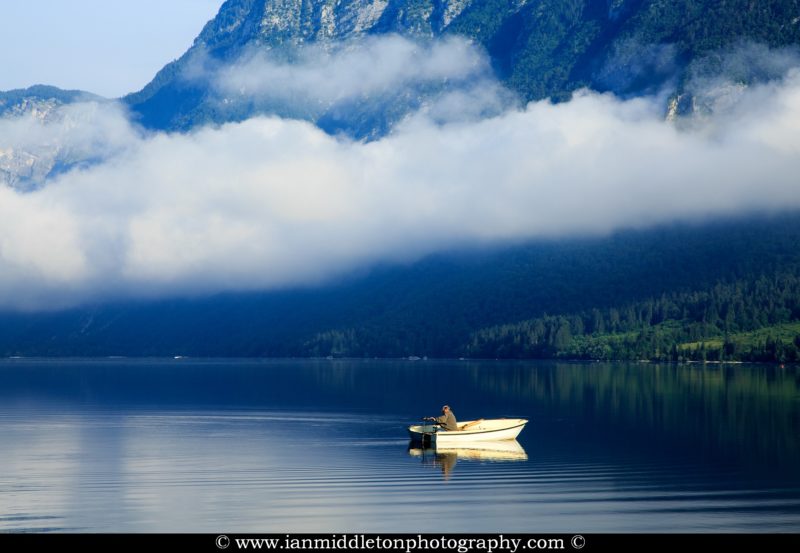 Man on his boat in the morning at Lake Bohinj, Triglav National Park, Slovenia