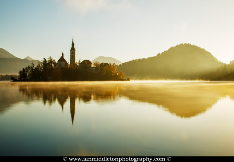 Warm morning sunlight over Lake Bled and the island church of the assumption of Mary, Slovenia.