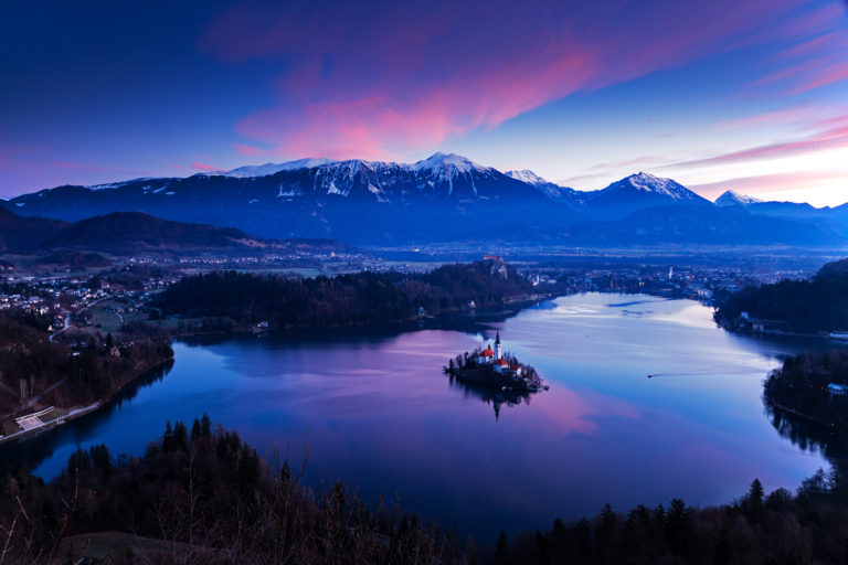 Sunrise over Lake Bled to the island church and clifftop castle from Mala Osojnica, Slovenia.