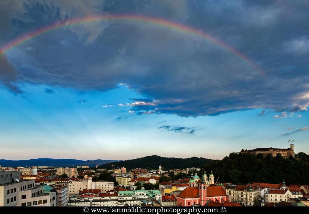 Ljubljana Castle and city centre with a rainbow over, Slovenia. Seen from Neboticnik terrace cafe.