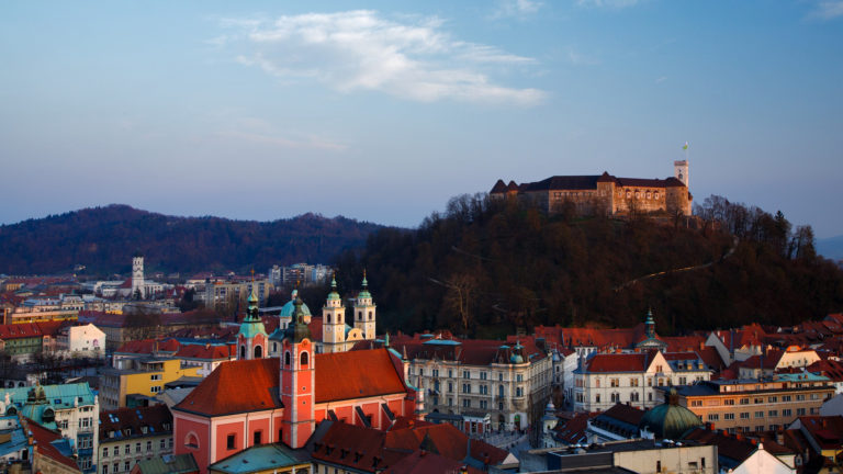 View across the centre of Ljubljana and the Franciscan Church and hilltop castle, Slovenia. Seen from Neboticnik, the skyscraper.