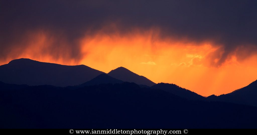 View of the sun setting against a stormy sky over the western mountains of Slovenia. This image was taken from a hill in Tunjice, near Kamnik, where you get a unobstructed view right across to the west.