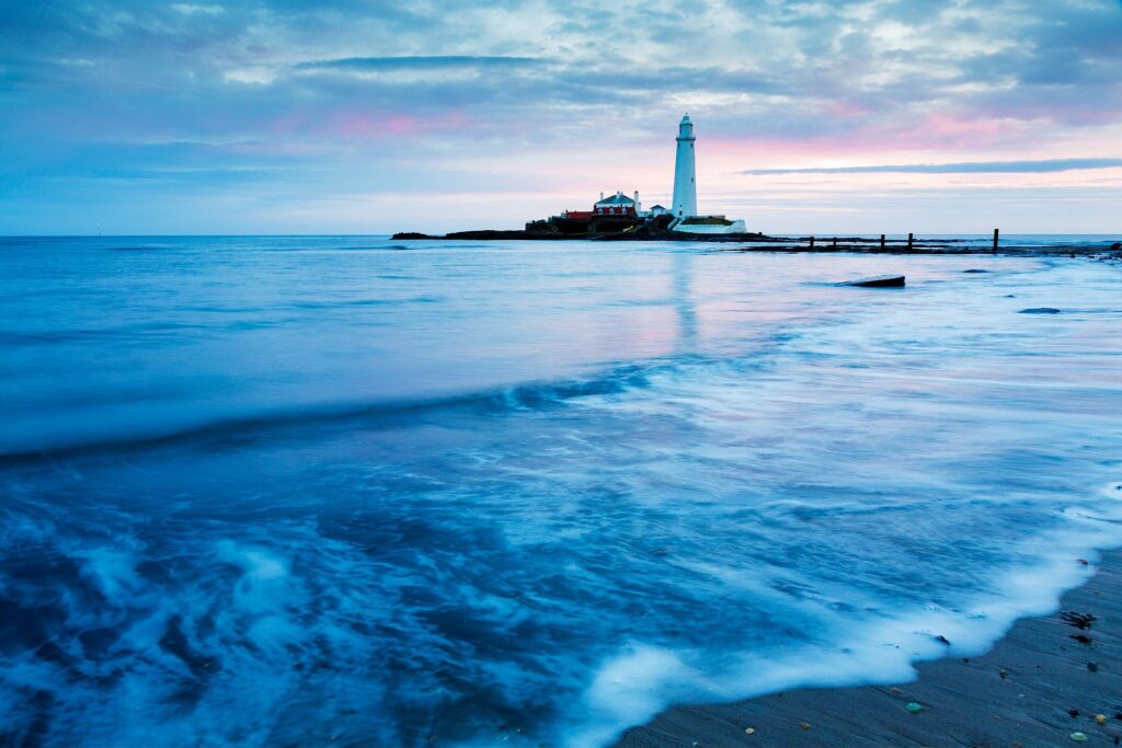 Saint Mary&#039;s Lighthouse on Saint Mary&#039;s Island, situated north of Whitley Bay, Tyne and Wear, North East England. Seen at sunrise from the beach beside the causeway that runs out to the island. Whitley Bay is situated just north of Newcastle.