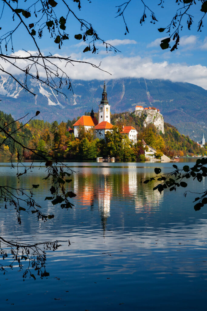 View across Lake Bled to the island church and clifftop castle in all it's autumn glory, Slovenia.