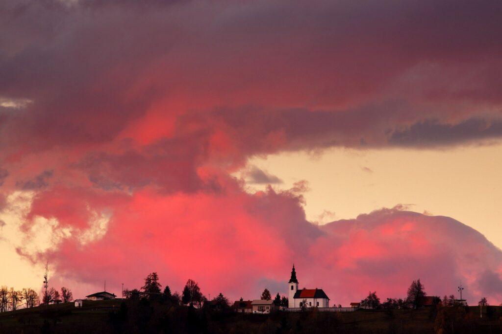 View across to the church of Saint Nicholas and the village of Jance at sunset, in the hilly region to the east of Ljubljana, Slovenia