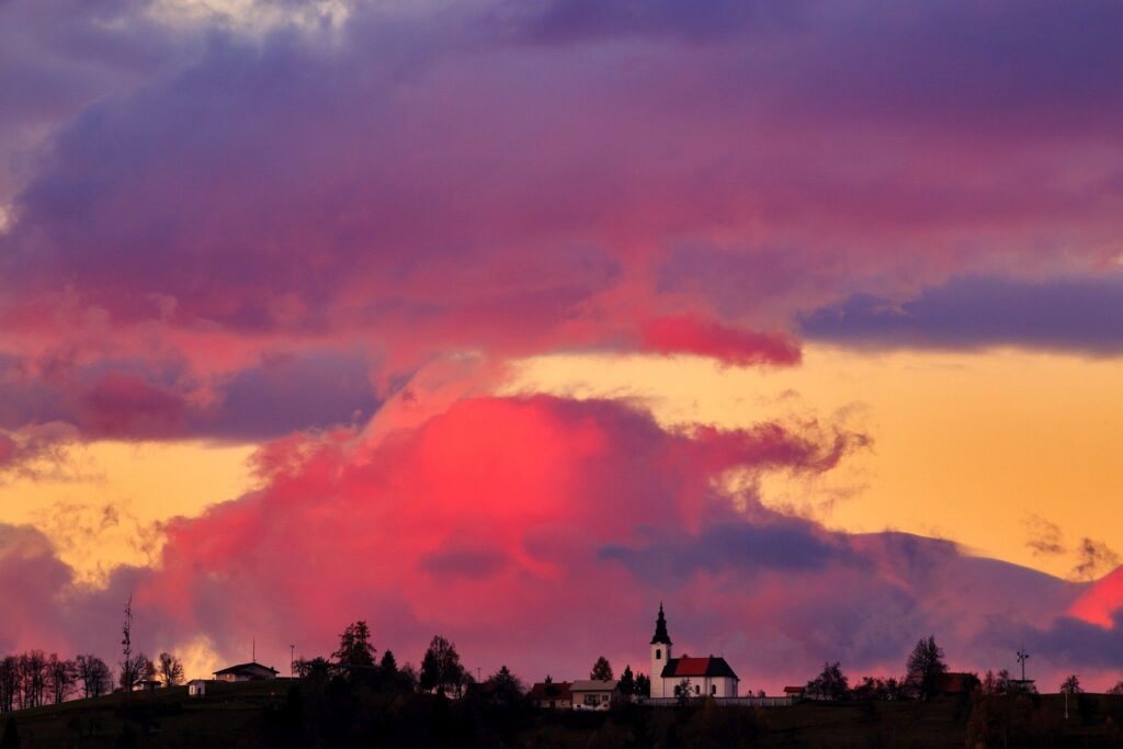 View across to the church of Saint Nicholas and the village of Jance at sunset, in the hilly region to the east of Ljubljana, Slovenia