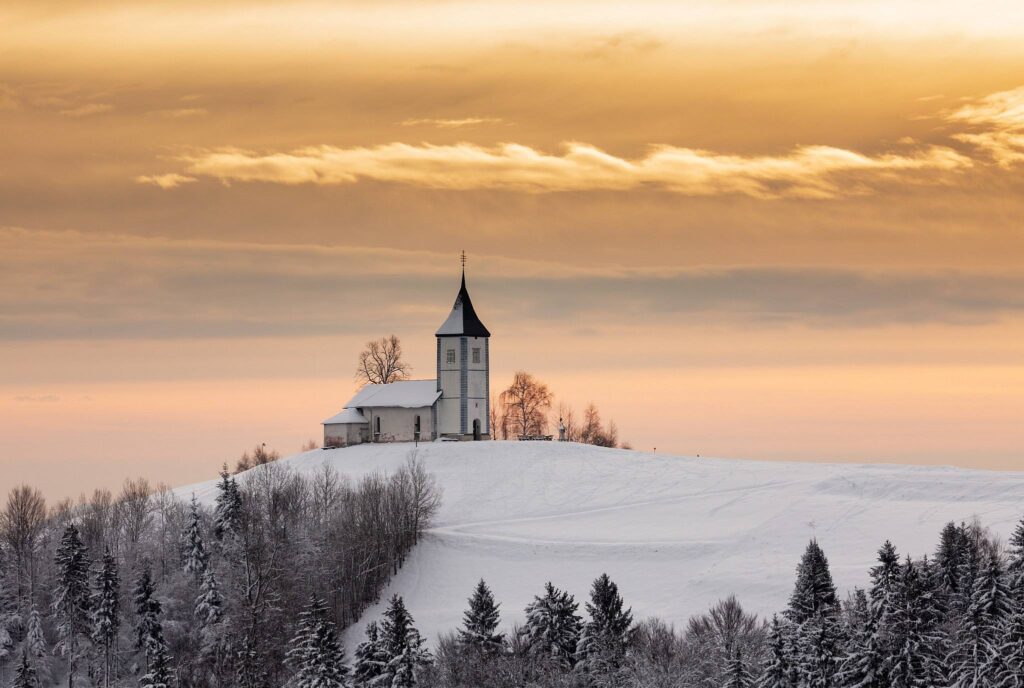 Jamnik church of Saints Primus and Felician in the morning in winter, perched on a hill on the Jelovica Plateau, Slovenia.