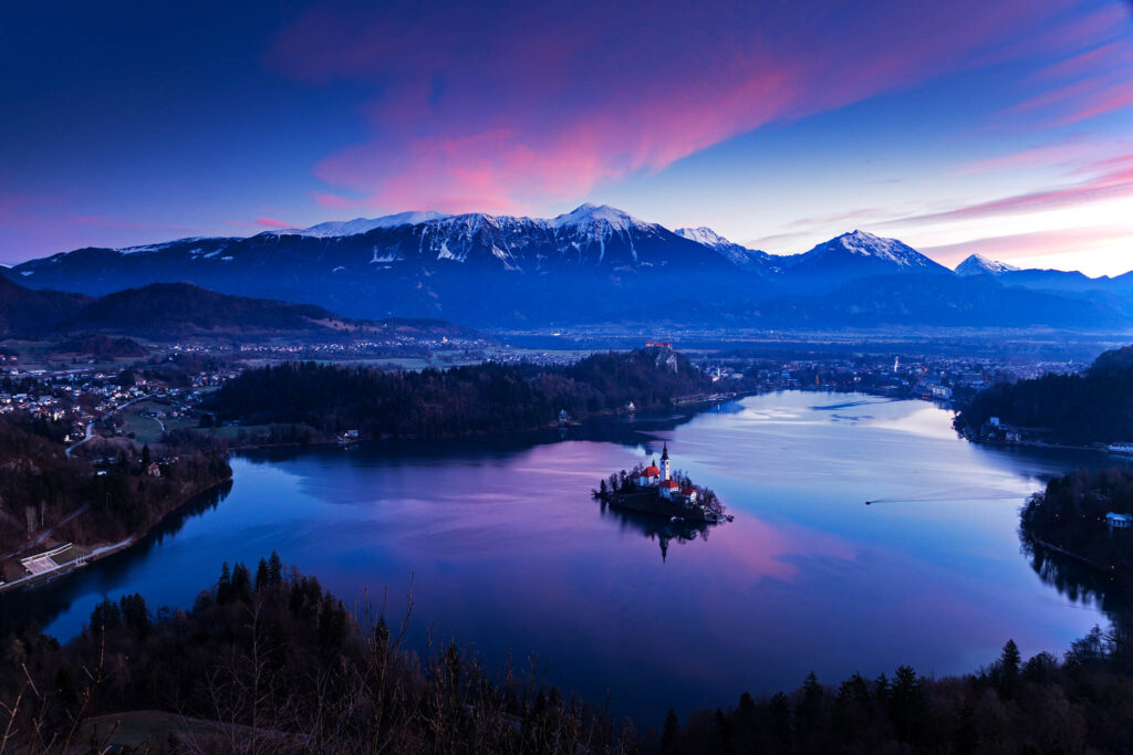 Sunrise over Lake Bled, the island church and clifftop castle from Mala Osojnica, Slovenia.