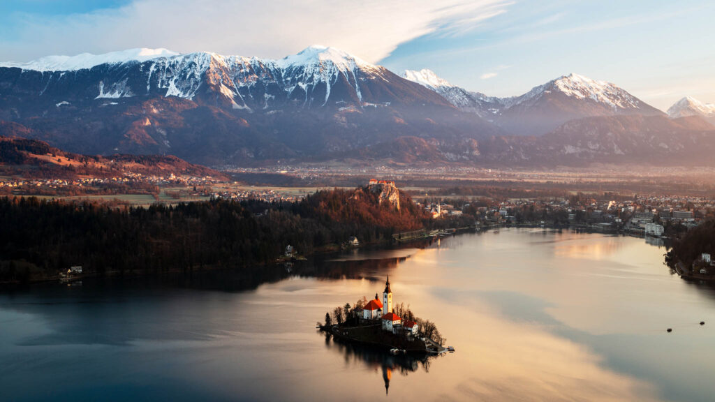 Morning over Lake Bled to the island church and clifftop castle from Mala Osojnica, Slovenia.