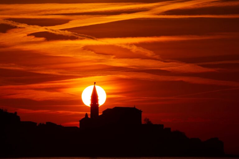 View of Saint George's Parish Church in Piran at sunset, seen from Strunjan, on the Adriatic Coast in Slovenia.