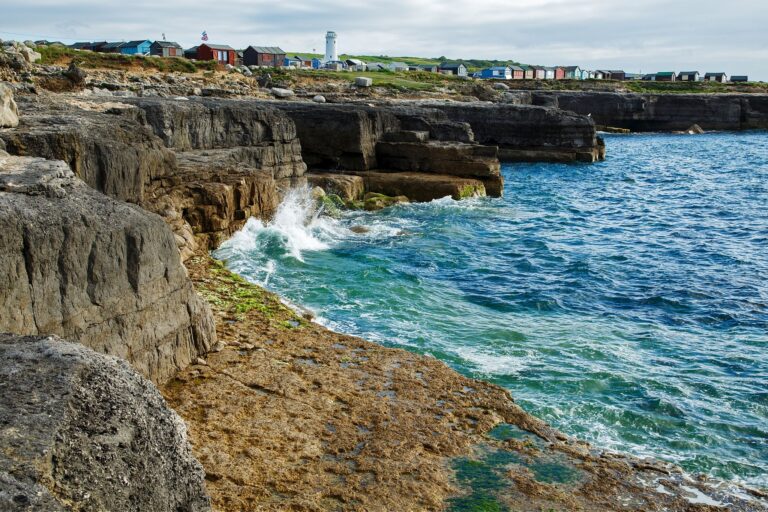 View across to the Old Higher Lighthouse at Branscombe Hill, Portland Bill in the early morning sun, near Weymouth, Jurassic Coast, Dorset, England.