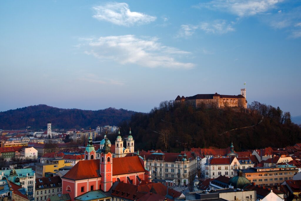 View across the centre of Ljubljana and the Franciscan Church and hilltop castle, Slovenia. Seen from Neboticnik, the skyscraper.