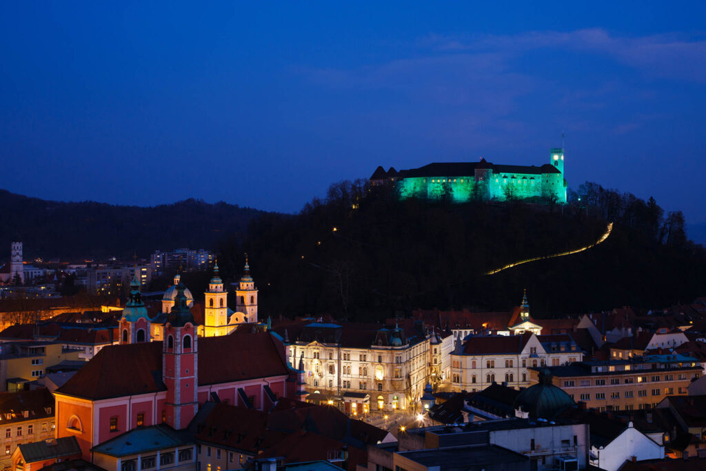 View down to the city centre of Ljubljana with the Ljubljana Castle lit up green to celebrate its status as European Green Capital 2016, Slovenia