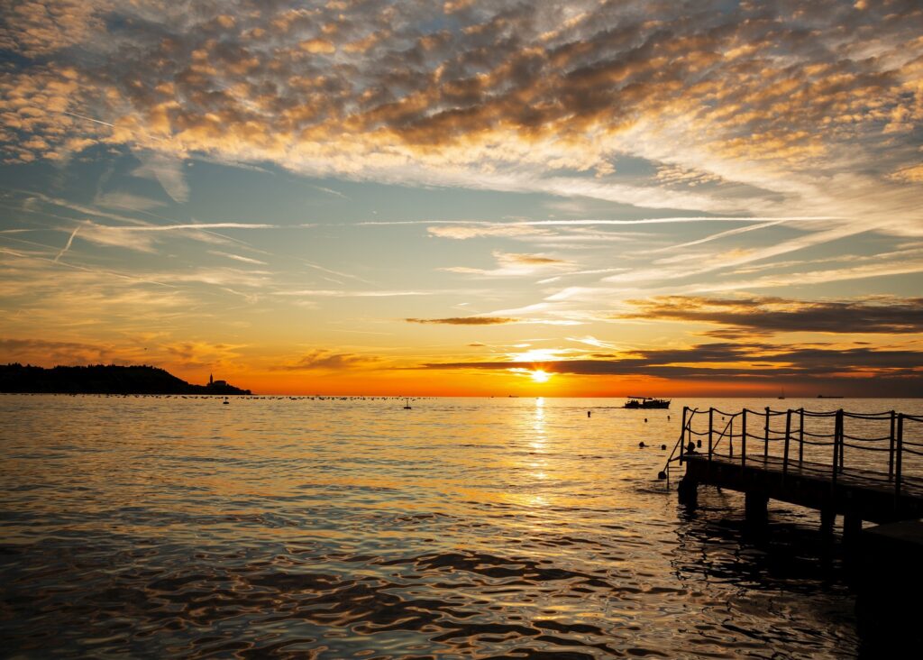 Sunset at Strunjan with the view of Saint George&#039;s Parish Church in Piran on the Adriatic Coast in Slovenia.