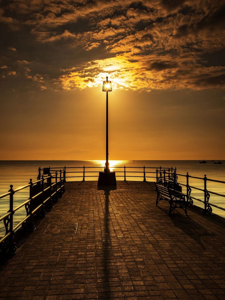 Sun rising behind the old cobbled Banjo Jetty in Swanage, Dorset, England.