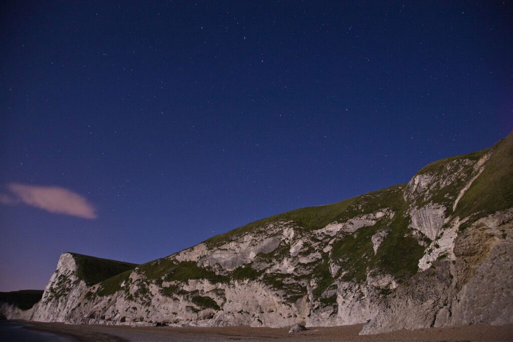 The Big dipper (Ursa Major) constellation on a moonlit light at Durdle Door beach, Dorset, England. Durdle door is one of the many stunning locations to visit on the Jurassic coast in southern England.