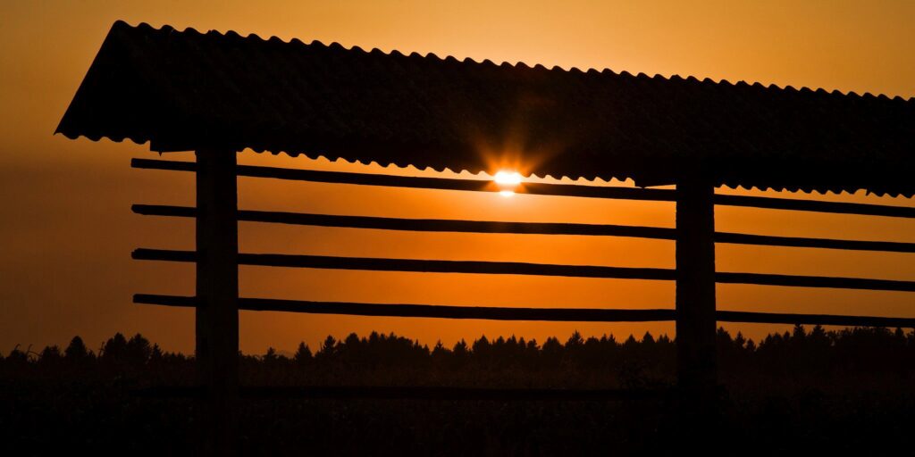 Summer sunset behind Kozolec (racks for drying hay), Spodnji Brnik, Slovenia. The Kozolec is a common sight in Slovenia.