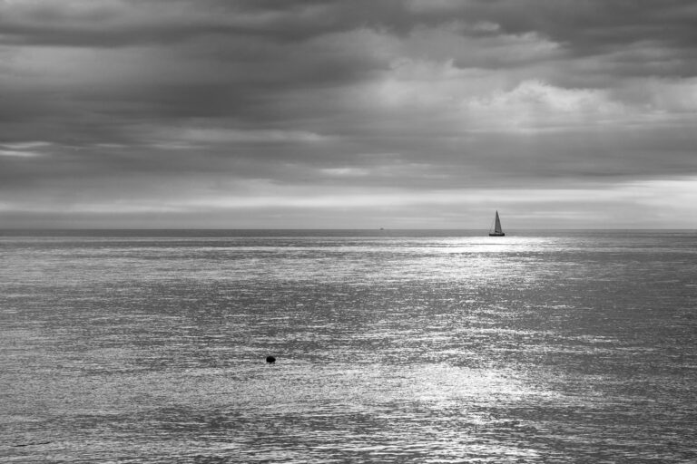 Beautful light breaks through the clouds as a sailing boat passes by on an otherwise empty sea at Kingsdown, Kent, England.