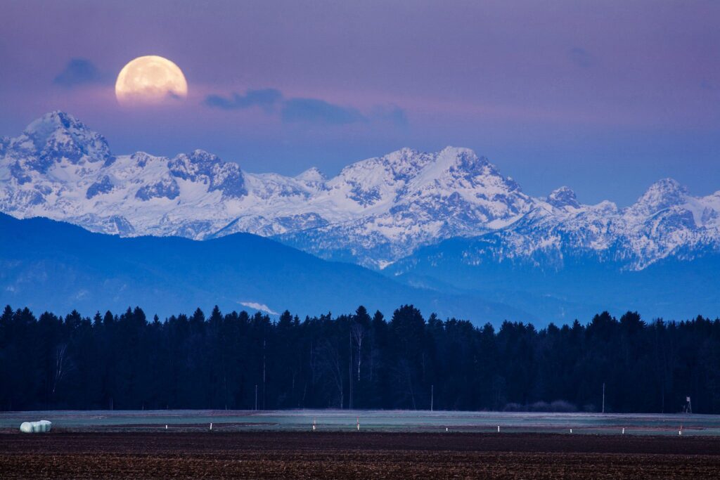 Full Moon setting over the Julian Alps in the morning, Brnik, Slovenia.