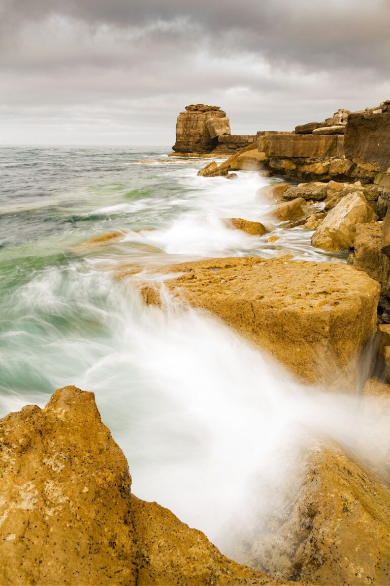 Waves crashing over Pulpit rock and the promontary at Portland Bill, near Weymouth, Jurassic Coast, Dorset, England. Pulpit Rock is an artificial stack that was left behind after quarrymen dug away a natural arch in 1870s. The Jurassic Coast is a stretch of coastline with a geology that dates back 185 million years, and is a UNESCO World Heritage Site.