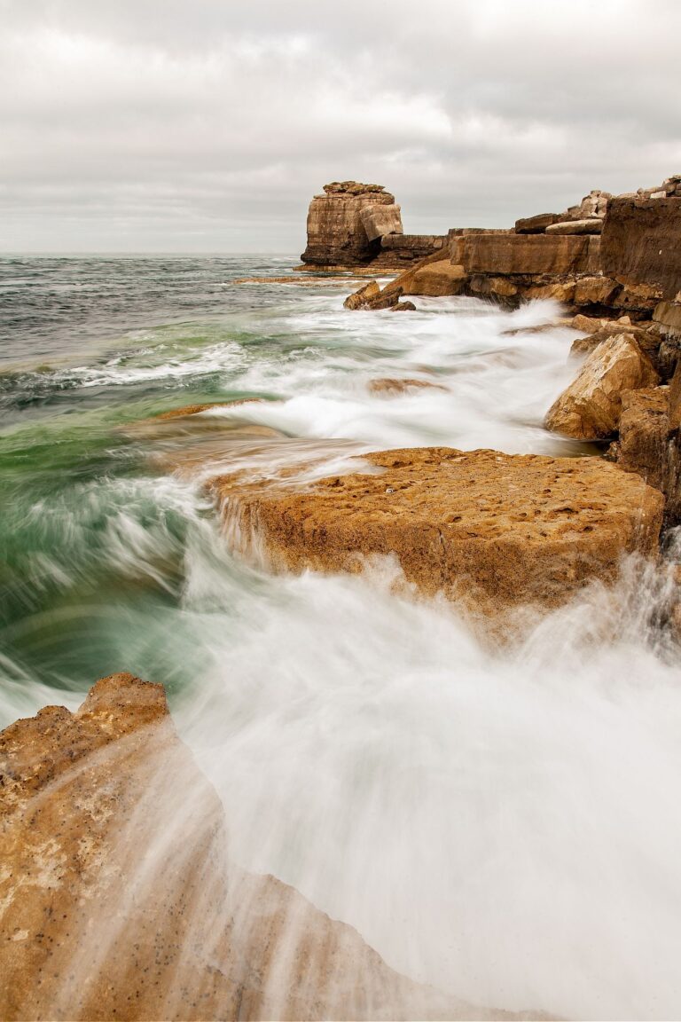 Waves crashing over Pulpit rock and the promontary at Portland Bill, near Weymouth, Jurassic Coast, Dorset, England. Pulpit Rock is an artificial stack that was left behind after quarrymen dug away a natural arch in 1870s. The Jurassic Coast is a stretch of coastline with a geology that dates back 185 million years, and is a UNESCO World Heritage Site.