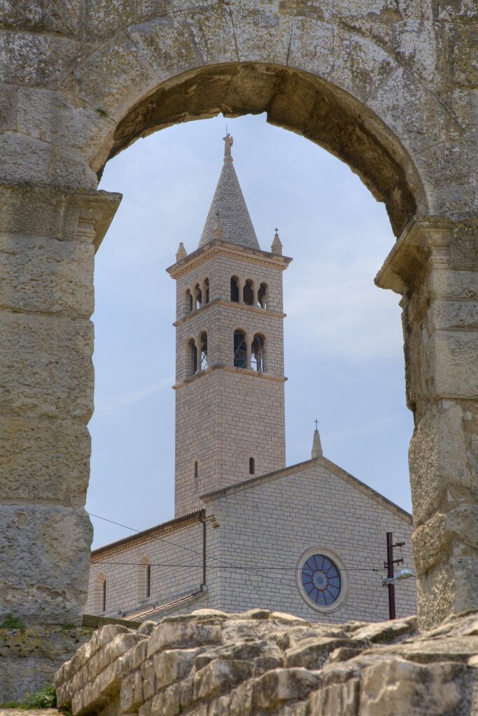 Church of St Anthony seen through archway of the Colosseum in pula, Croatia