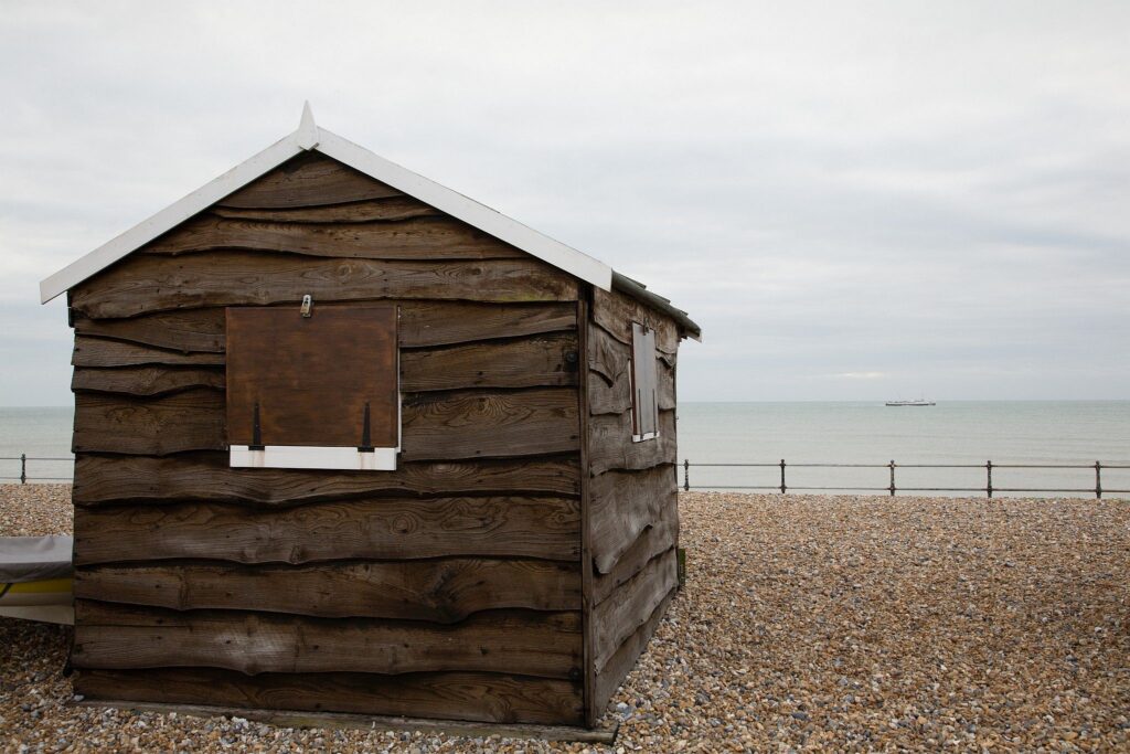 Brown beach hut in the morning at Kingsdown beach, near the famous White Cliffs of Dover, Kent, England. These wooden beach huts are an iconic piece of the English coast