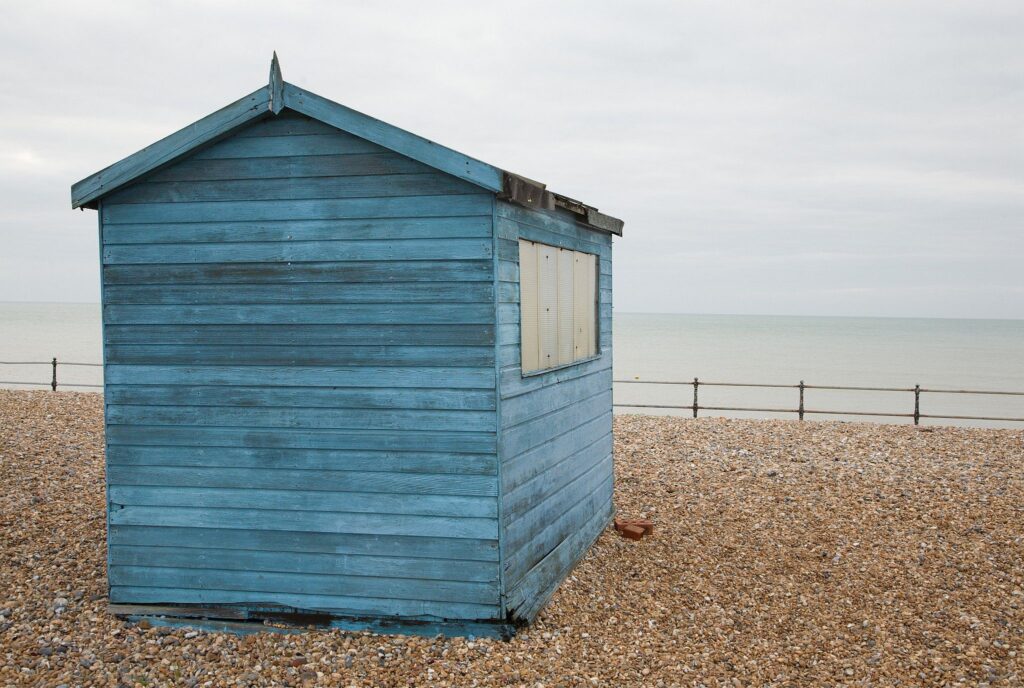 Blue beach hut in the morning at Kingsdown beach, near the famous White Cliffs of Dover, Kent, England. These wooden beach huts are an iconic piece of the English coast