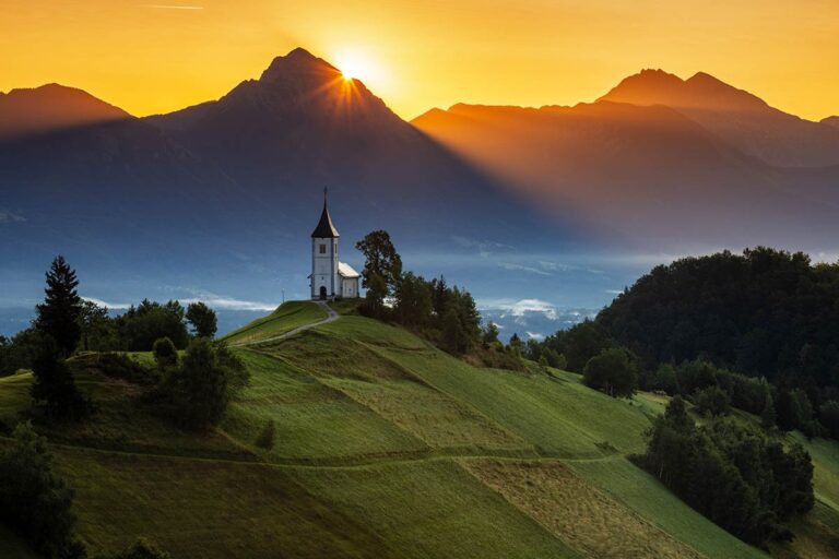 Sun rising over Mt Storzic behind Jamnik Church