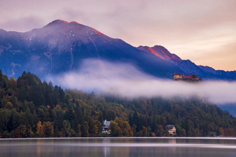 Beautiful autumn morning light and alpenglow across Lake Bled hilltop castle and Mount Stol, the highest peak in the Karavanke Mountains. Slovenia.