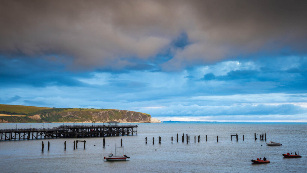 View of the old pier in Swanage with Old Harry Cliffs in the background, Dorset, England.