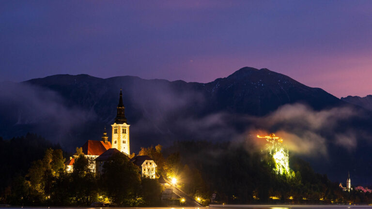 Sun rising over Lake Bled and the island church of the assumption of Mary with the Karavanke mountains in the background, Slovenia.