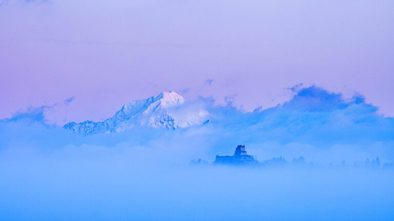 View across to Smlednik Castle and Storzic mountain, part of the Kamnik Alps, as they emerge from the fog at sunrise.