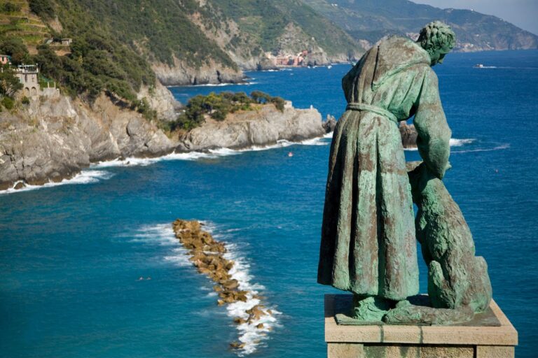 Statue of Saint Francis of Assisi petting a dog and looking out over Monterosso al Mar, Liguria, Italy. First of five towns and villages on the Cinque Terre, five lands.