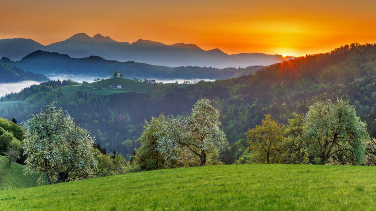 Spring view at sunrise from Rantovše hill across to Sveti Tomaz nad Praprotnim (church of Saint Thomas) and the Kamnik Alps, Slovenia.
