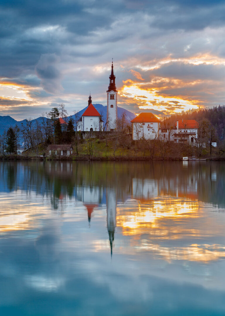 Sun rising over Lake Bled and the island church of the assumption of Mary with the Karavanke mountains in the background, Slovenia.