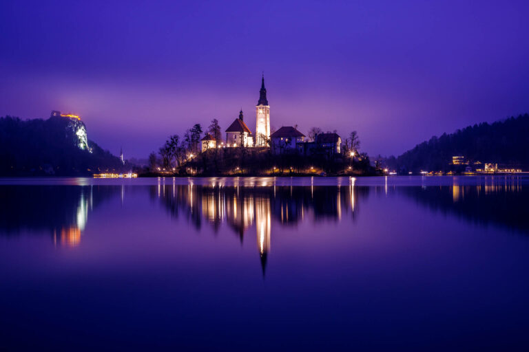 View across the beautiful Lake Bled, island church and hilltop castle at dusk, Slovenia.