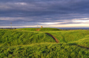 Iron age rath at the Hill of Tara in County Meath, Ireland. Tara was once the ancient capital of Ireland, from where the high king ruled over the country. The upright stone you see on the mound is the Lia Fail (stone of destiny). According to Celtic legend the Lia Fail was used during the coronation of the high king, and was believe to emit a roar when the true high king touched it. It was also the place where Samhain was celebrated.